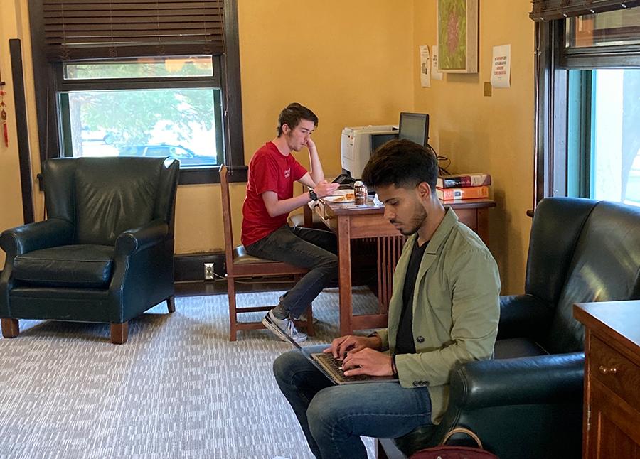  Two men seated in an office working on computers